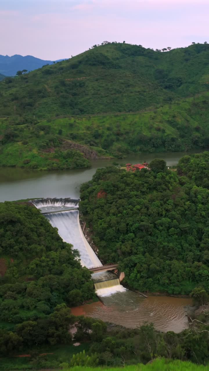 Stunning aerial footage of Presa EL Carrizo in lush Tamazula de Gordiano, Jalisco. Rich, vibrant greens with flowing water under dramatic skies captured in vertical video