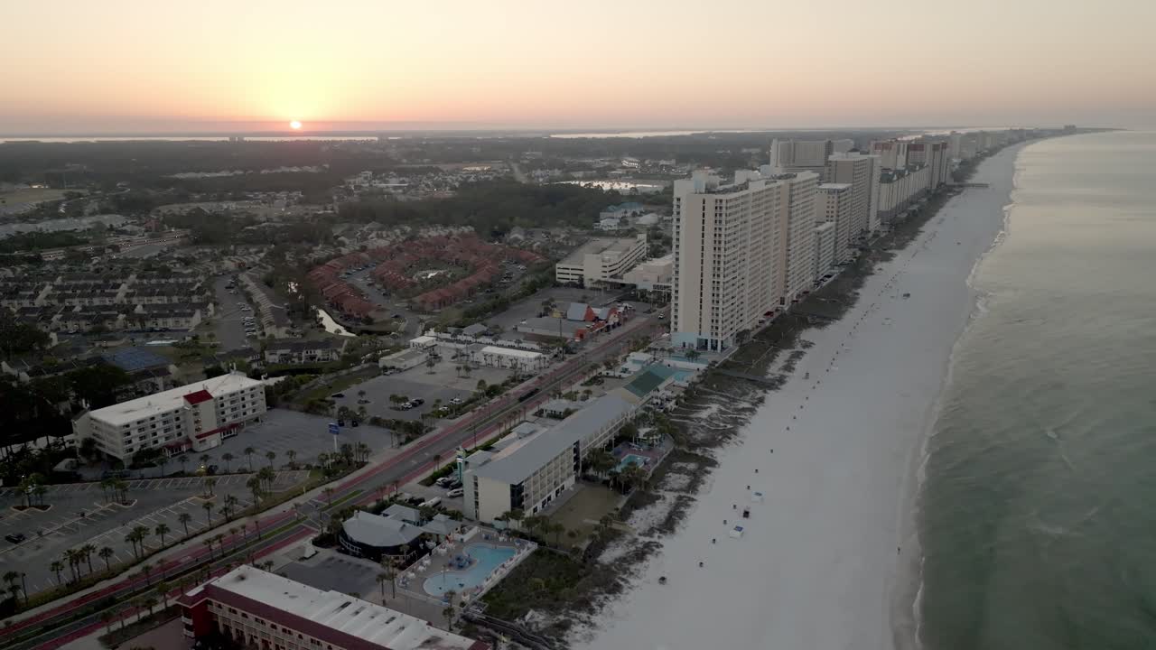 Sunrise in Panama City Beach, Florida showing hotels and Gulf of America with drone video moving left to right up high.
