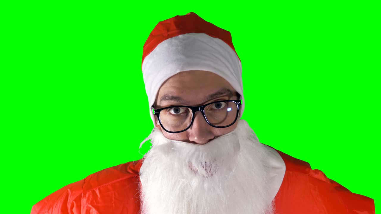 un primer plano de santa claus levantando las cejas sobre un fondo verde.