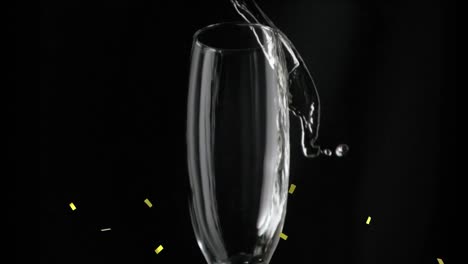 animation of gold confetti falling over glass of champagne on black background