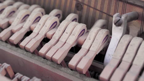 closeup of old broken piano hammers hitting strings