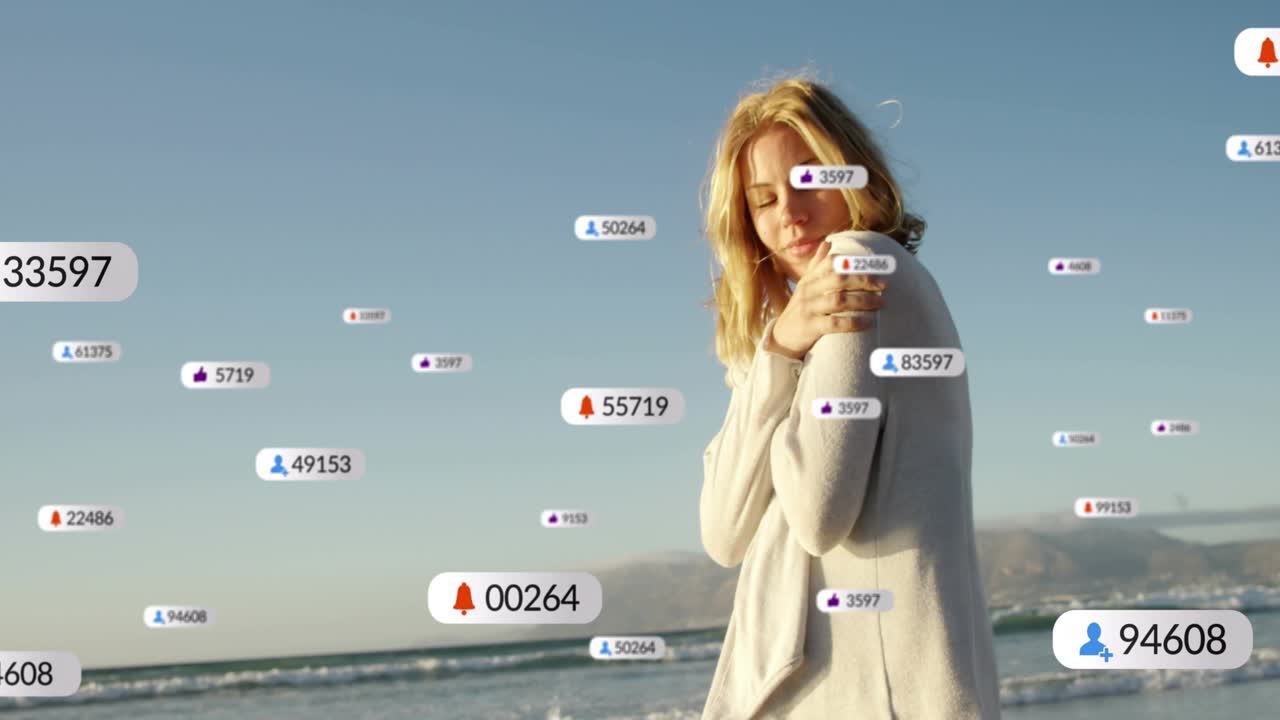 Woman standing shore hugging arms turning and reacting as social media badges appearing around her