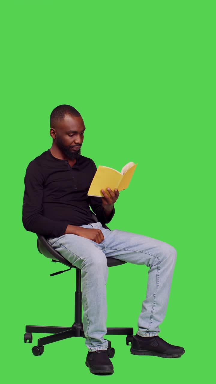 Vertical video: Side view of focused person reading story tale book in studio