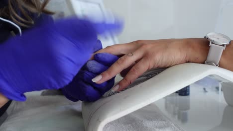 maestro haciendo manicura con lima de uñas película de primer plano