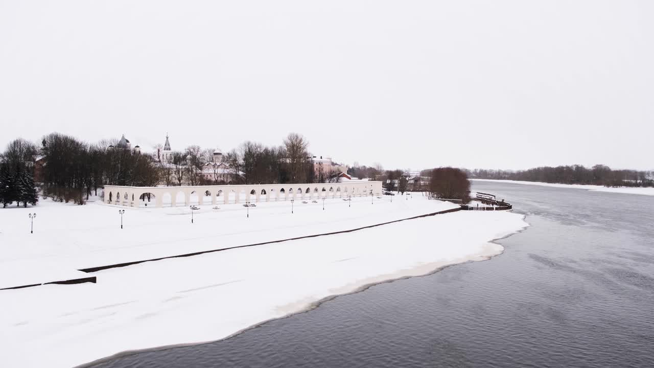 снежный городской пейзаж с рекой и аркой