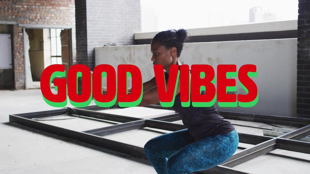 Adult woman starting squats with green ball GOOD VIBES graphic appearing marking motion for fitness
