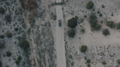 drone shot of truck driving through desert