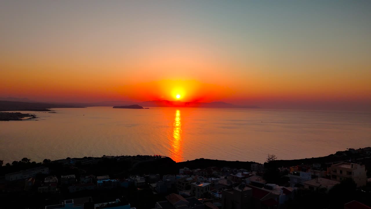 The sun sets over the tranquil sea, casting warm colors across the sky and reflecting on the water. This peaceful moment captures the beauty of nature in a coastal location