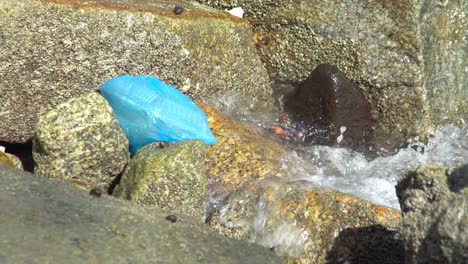 Blaue-Plastiktüte-Mit-Lebensmittelbehälter,-Der-Von-Der-Welle-Getroffen-Wird