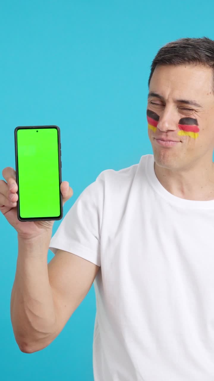German man looking at his mobile smiling and showing it