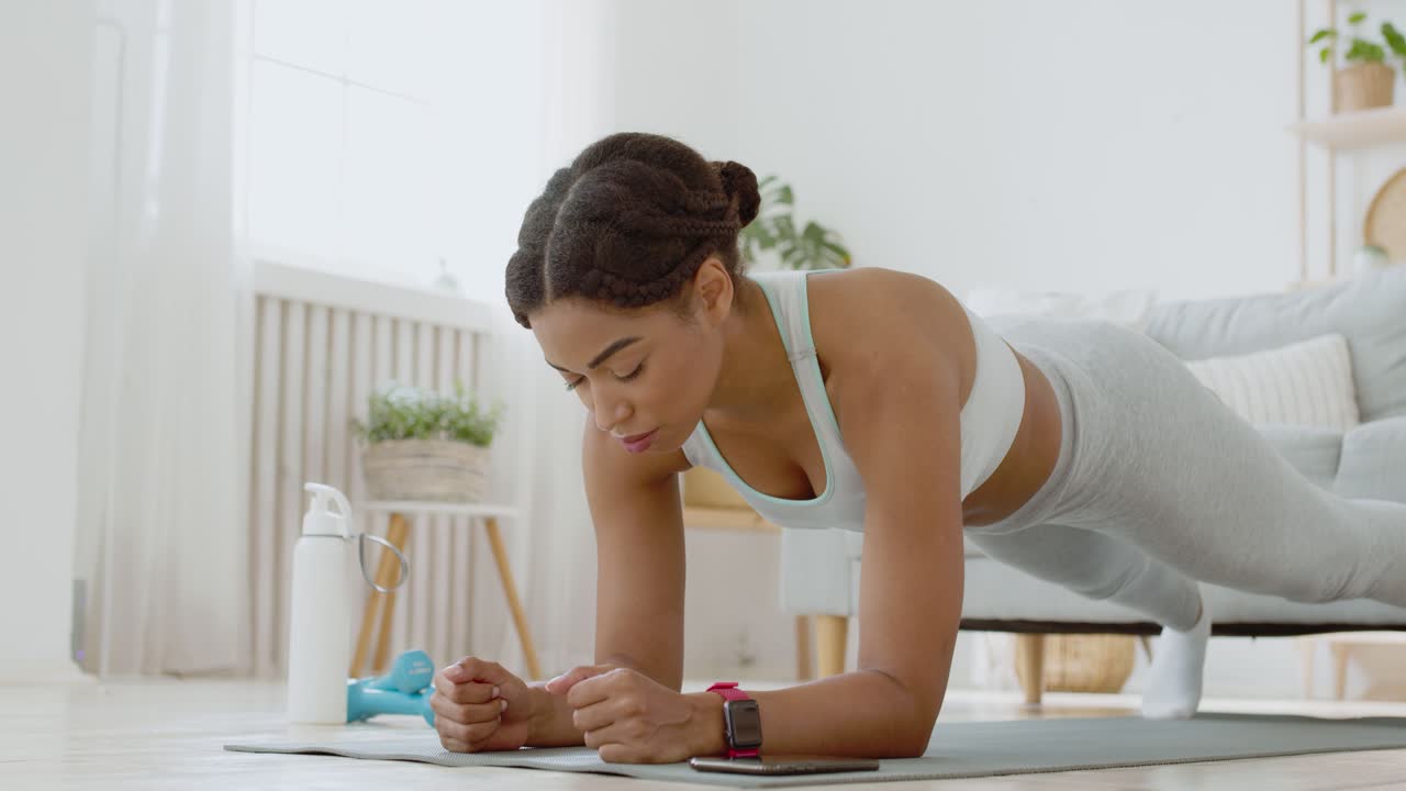mujer haciendo ejercicio de tabla en casa