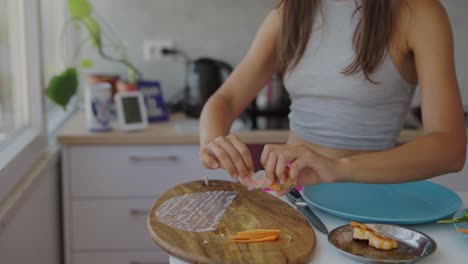 close-up of a person preparing fresh spring rolls in a kitchen