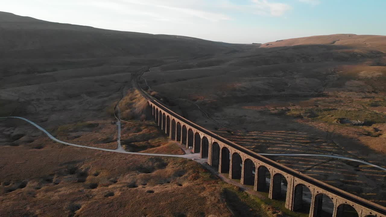 Aerial shot of Ribblehead Viaduct at sunset. Flying backwards and revealing the viaduct