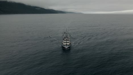 A-Lone-Fishing-Boat,-Trawler-Sailing-On-The-Deep-Blue-Sea-In-Quebec,-Canada-Under-The-Cloudy-Sky