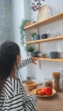 mujer en la cocina mirando especias y estantes