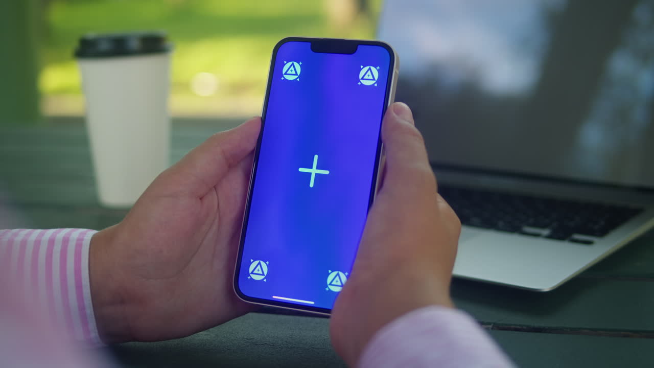 Woman hand holding phone with chroma key screen outdoor. Smartphone with green screen close-up