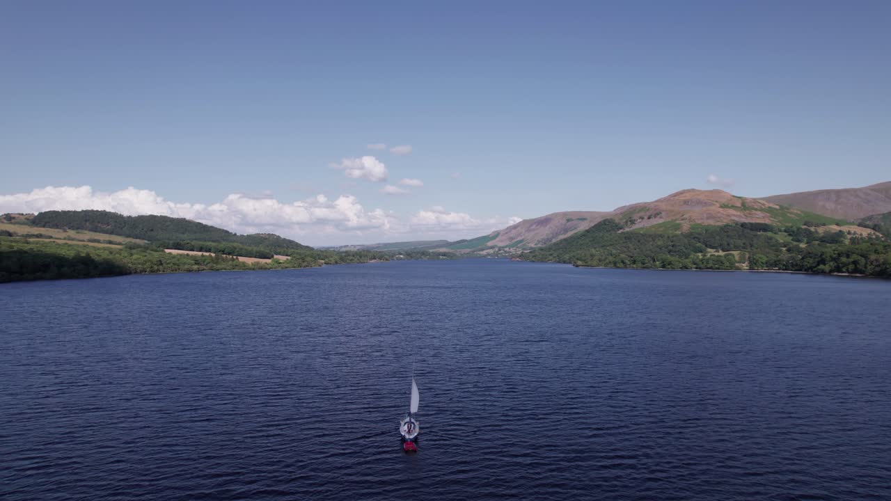 화창한 날, 울스워터, 호수 지구, 컴브리아, 영국에서 항해 보트 위로 앞으로 날아가는 느린 드론 샷