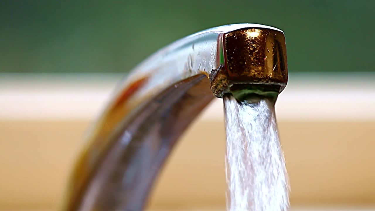 Water pouring from a mixer tap in a kitchen