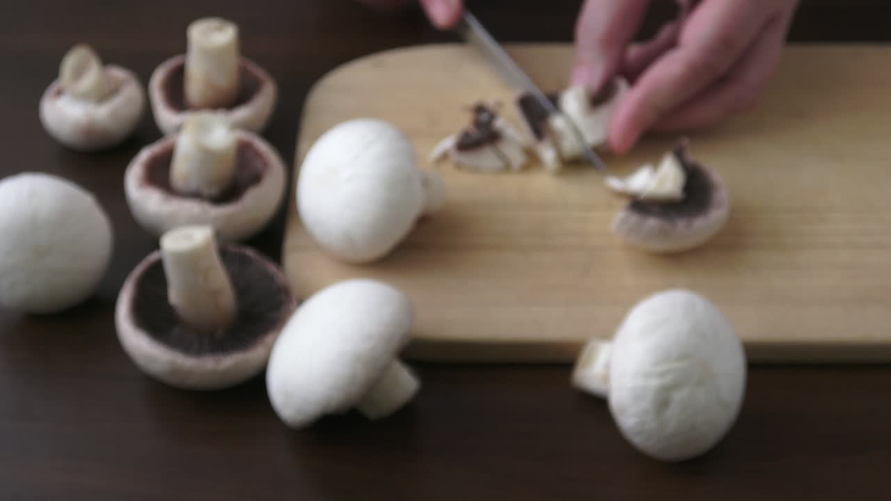 주방 칼을 들고 질과  버섯을 잘라내는 여자