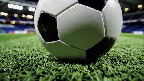 una pelota de fútbol en un campo por la noche en un estadio