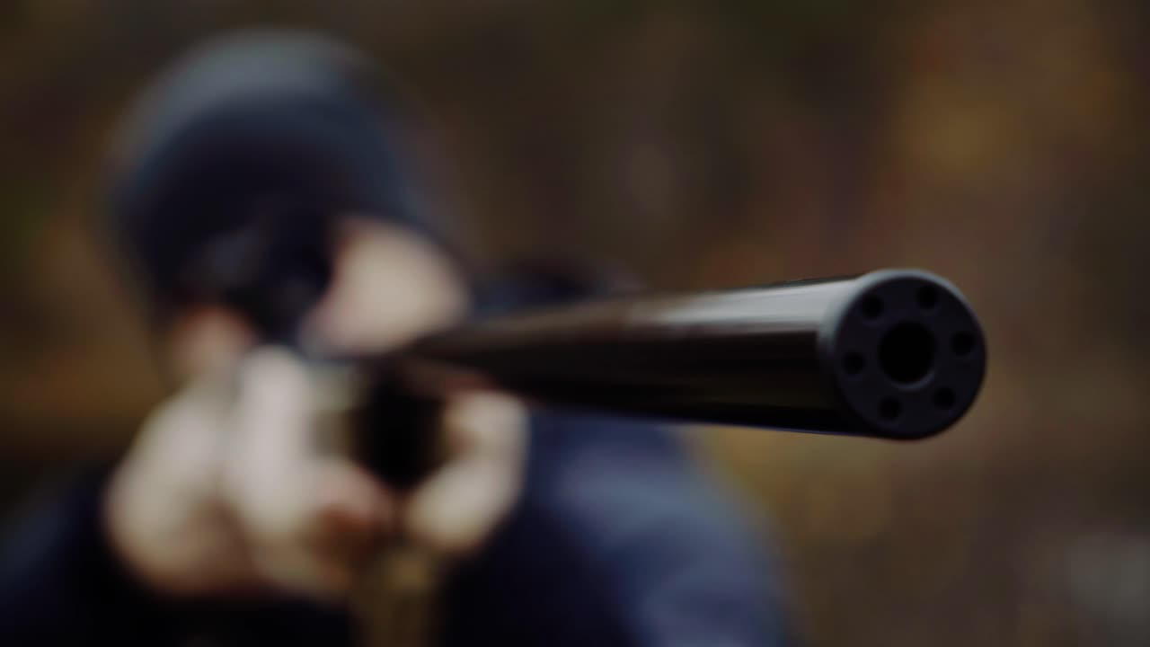 Hunter holding hunting rifle. Close up of young hunter holding hunting rifle aiming in forest