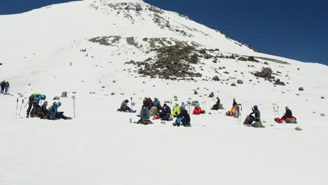 excursionistas descansando en una cumbre de montaña cubierta de nieve