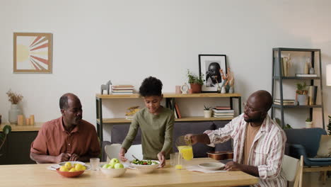 schwarze männer und ein junge essen zu hause zu mittag.