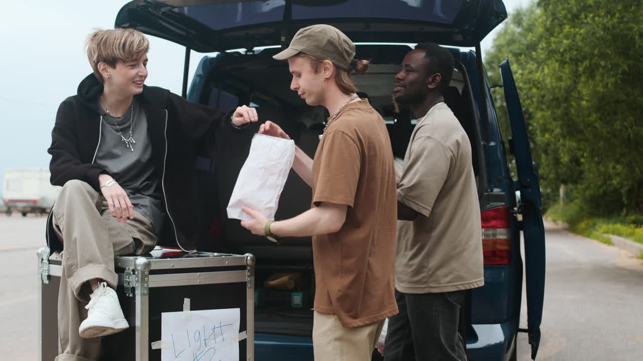 록 밴드 멤버들이 야외에서 이야기하고 있습니다.