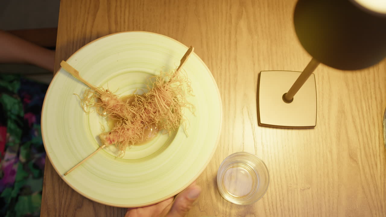 Hand Of The Waiter Bringing The Shrimps Dish On The Restaurant Table