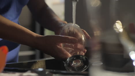 Woman-washing-wineglass-in-the-kitchen