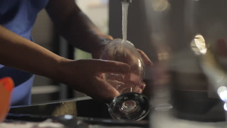 woman washing wineglass in the kitchen