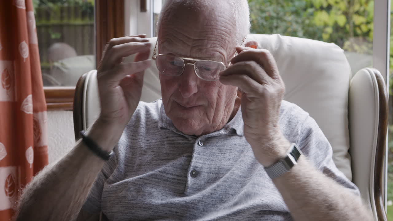 Elderly Man with Glasses Sitting in Chair