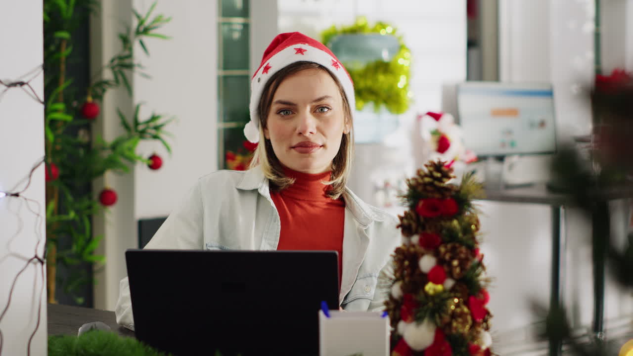Woman wearing Santa hat working on laptop during Christmas