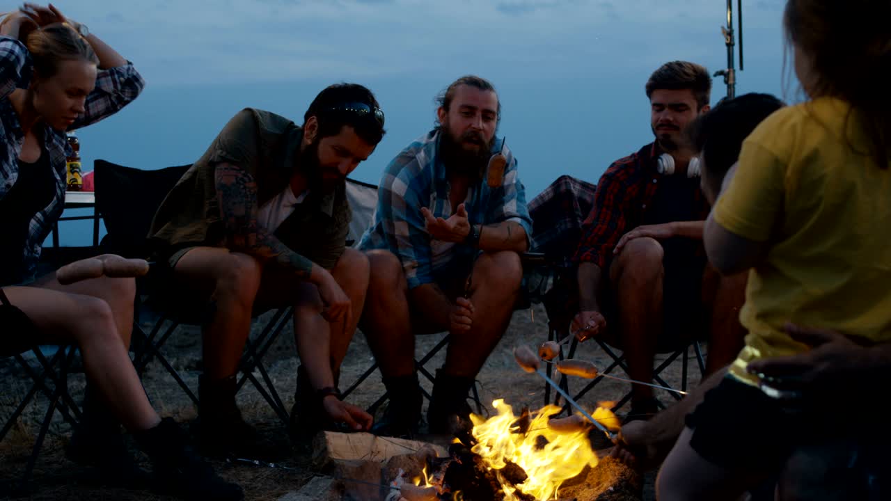 캠핑장에서 소시지를 는 여행하는 친구들의 그룹