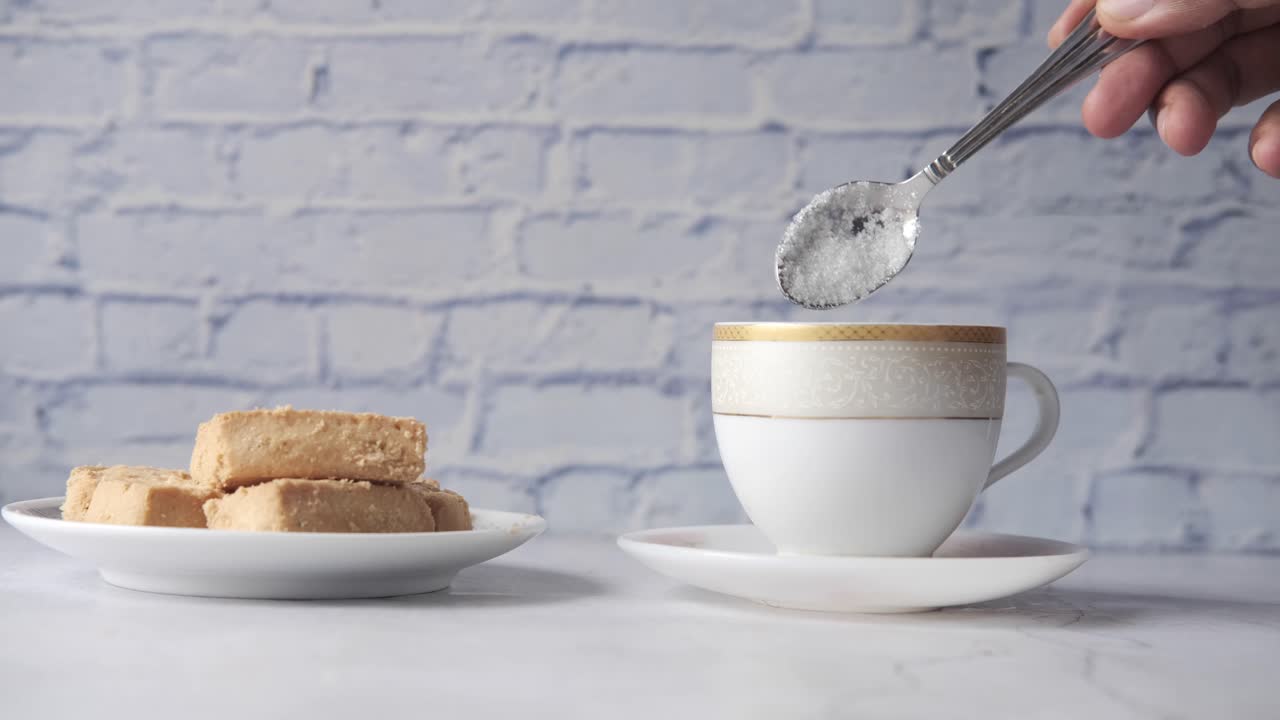 añadiendo azúcar al té con galletas