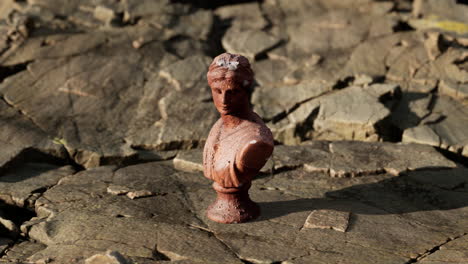 ancient-statue-of-woman-on-rocky-stones