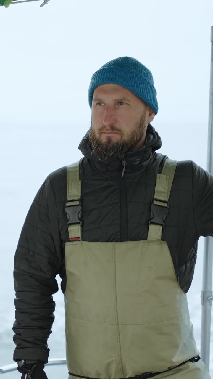 Man in Blue Beanie and Overalls on a Boat