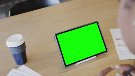 mujer de negocios caucásica en una videollamada de tableta con pantalla verde