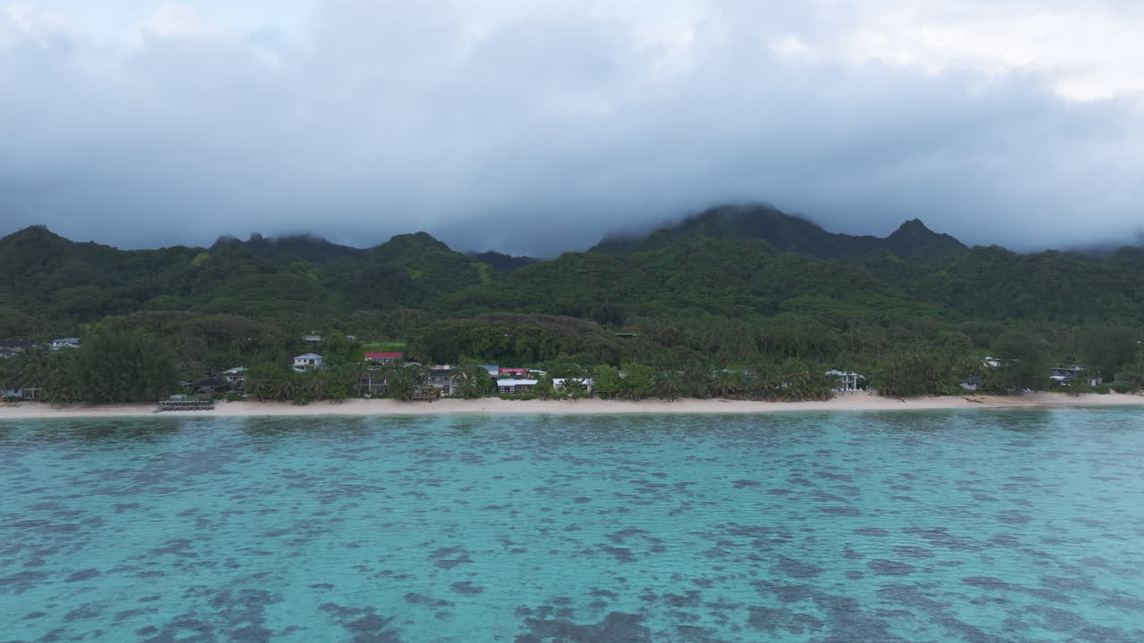 Dusk approach to coastline of Cook Islands Rarotonga with white sandy beach and protected waters