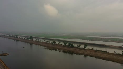 Aufsteigender-Luftblick-über-Die-Wasserstraße,-Um-Landwirtschaftliches-Ackerland-In-Sindh-Zu-Enthüllen