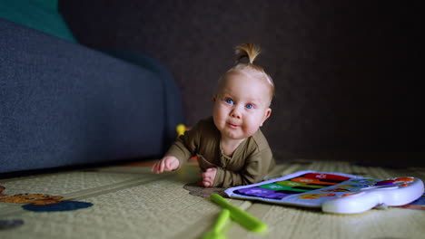 lovely cute blond baby crawls by the floor. adorable child is in his room around the toys.