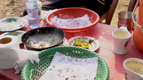 messy table with leftover food at an outdoor cafe