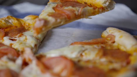 primer plano extremo del uso de un servidor de pizza para quitar un trozo de pizza de una bandeja de pizza en cámara lenta