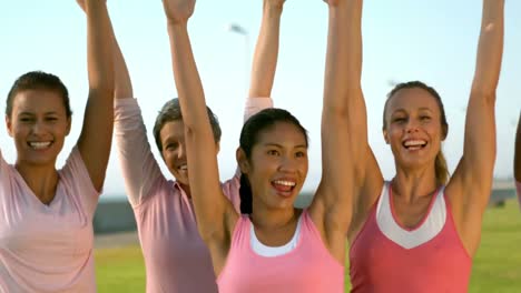 mujeres sonrientes vestidas de rosa por el cáncer de mama y aclamando
