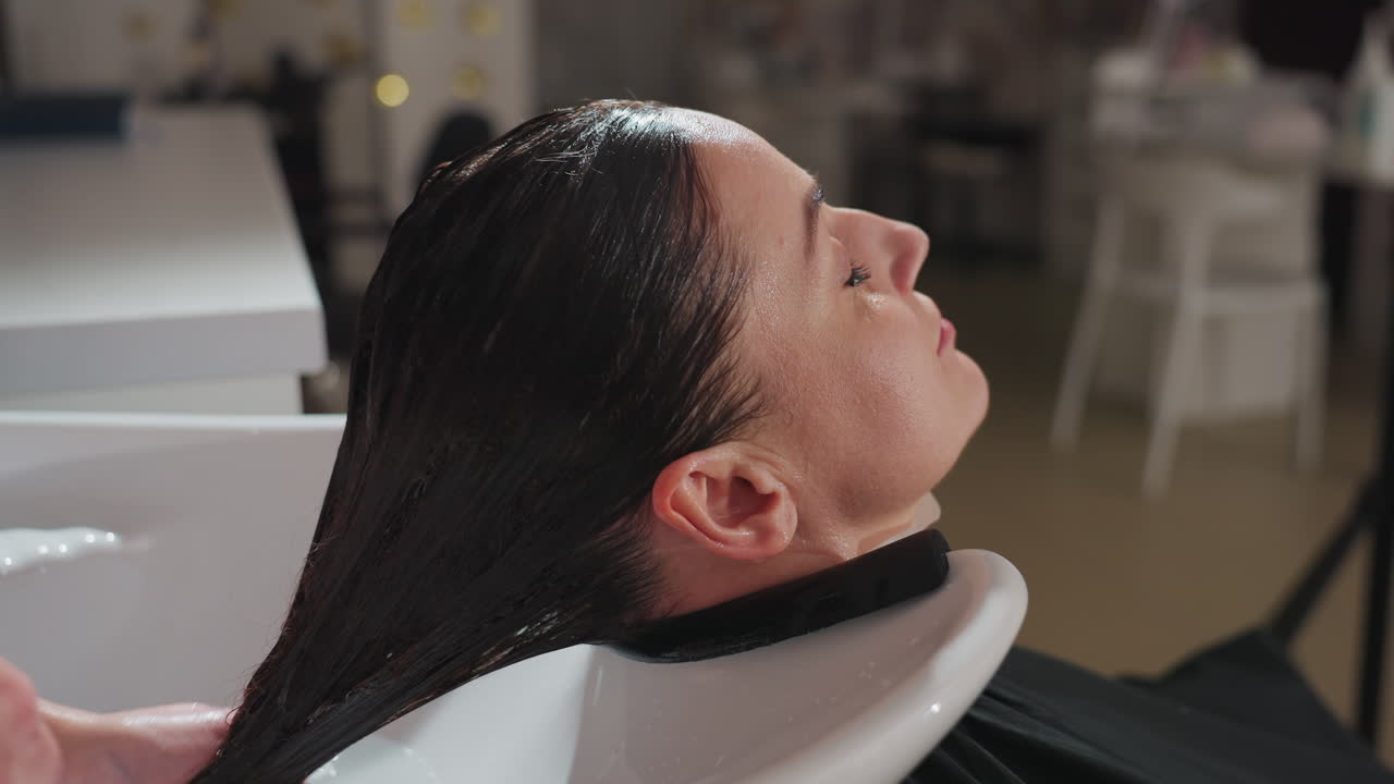 편안한 두피 마사지, 머리 감는 동안의 평화로운 순간, 부드러운 두피 관리, 여성이 편안한 두피 마사지와 머리 클렌징을 즐기는 동안의 고요한 분위기가 있는 평온한 환경