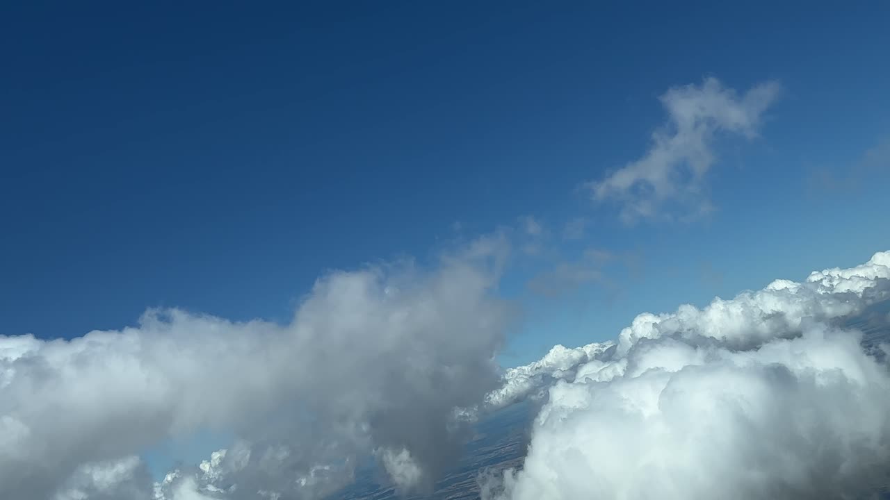 An unique pilot&rsquo;s perspective: flying across a typical summer sky, diring a right turn, with some tiny cumulus clouds in a splendid summer afternoon