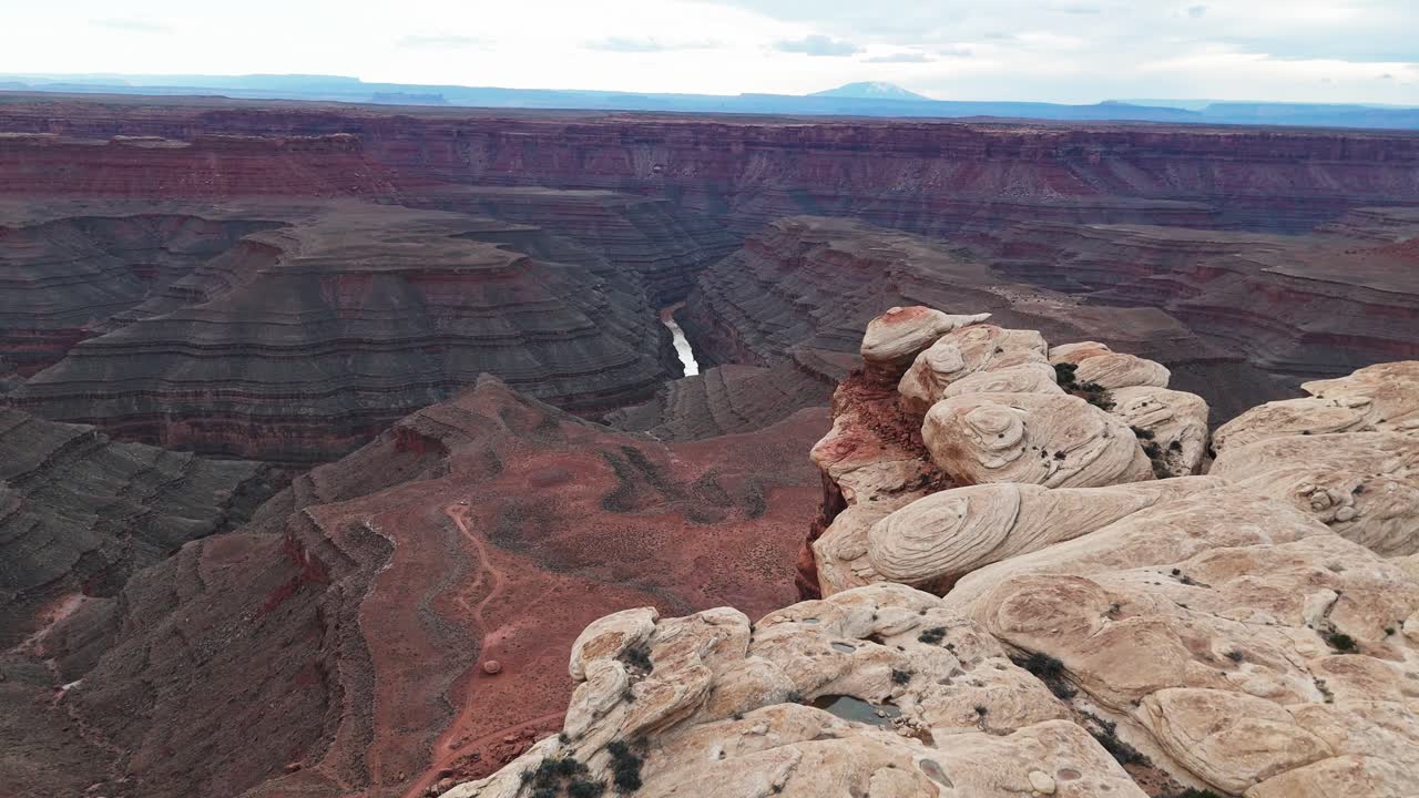 Lot drona nad skalistym płaskowyżem, ukazujący kanion Goosenecks w Utah