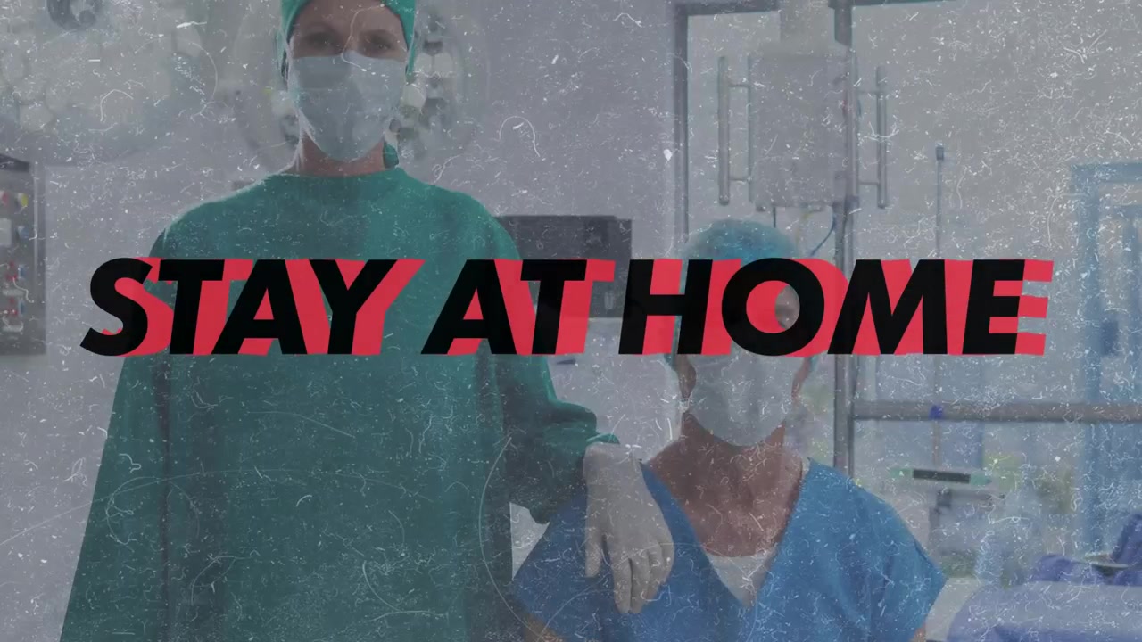 Slogan che appare a fuoco mentre un medico e un'infermiera si tolgono le mascherine, posizionando una mano guantata per esortare alla sicurezza.