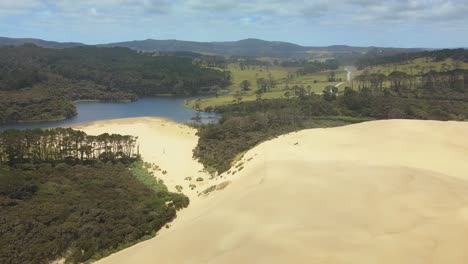 Vista-Aérea-Sobre-Las-Dunas-De-Arena-Gigantes-Y-El-Lago-Ngakeketa-En-Nueva-Zelanda