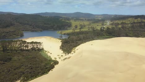 aerial view over the giant sand dunes and lake ngakeketa in new zealand